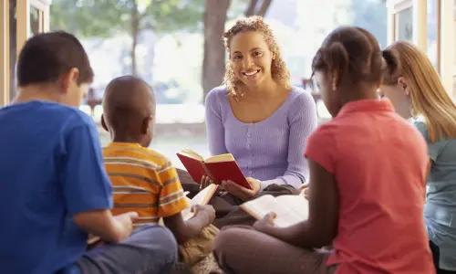 A teacher reading to a group of students.