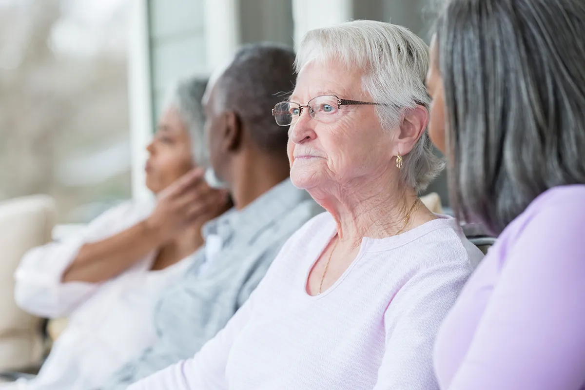 Group of older adults sitting together. Find out how dementia can impact the risk of elder abuse.