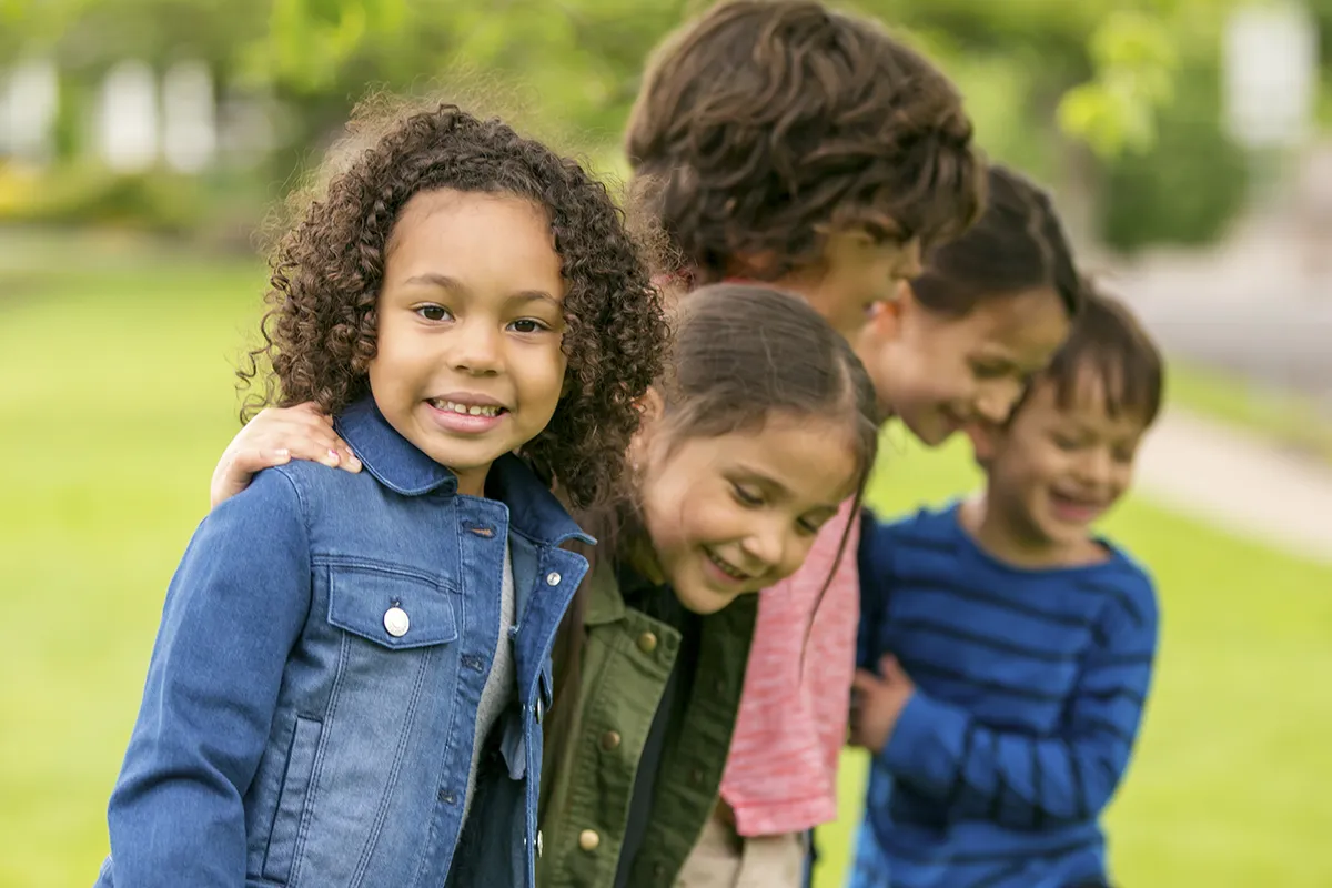 A group of school-aged children playing outside in a green grassy environment. Learn how to find approved PA Act 31 training.